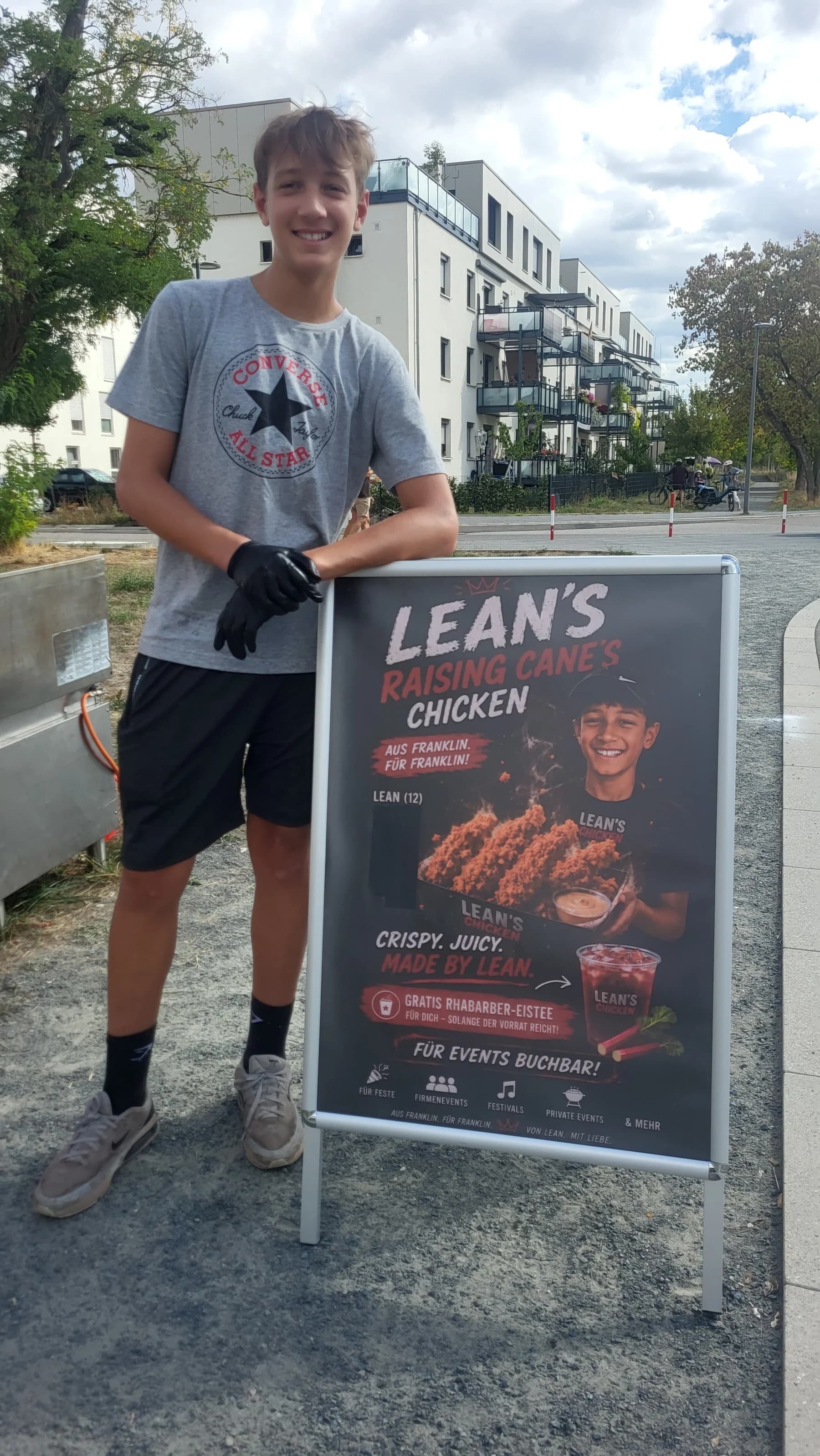Lean steht neben dem Lean's-Raising-Canes-Chicken-Aufsteller